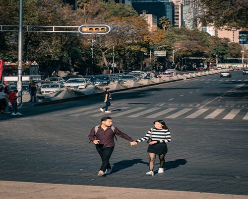 A person walking comfortably down a sunny street in Mexico City